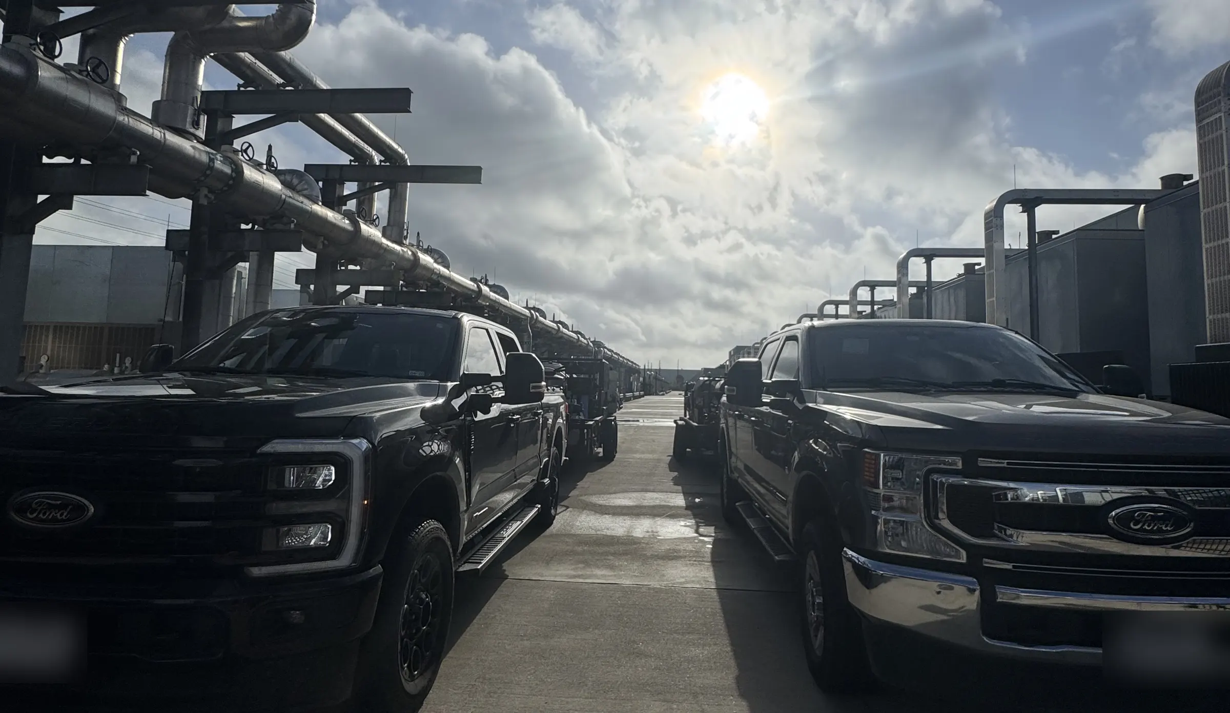 Mission Level Services black Ford F-250 work trucks and wash trailers on a commercial job in Houston, TX