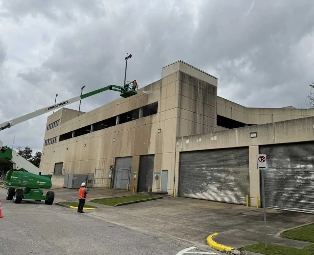 Mission Level Services washing a commercial building from a boom lift