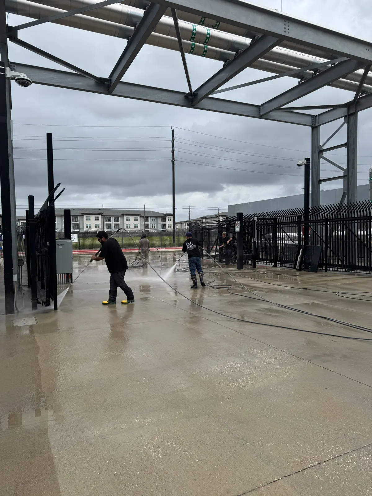 Mission Level Services crew pressure washing a commercial concrete lot in Houston, TX