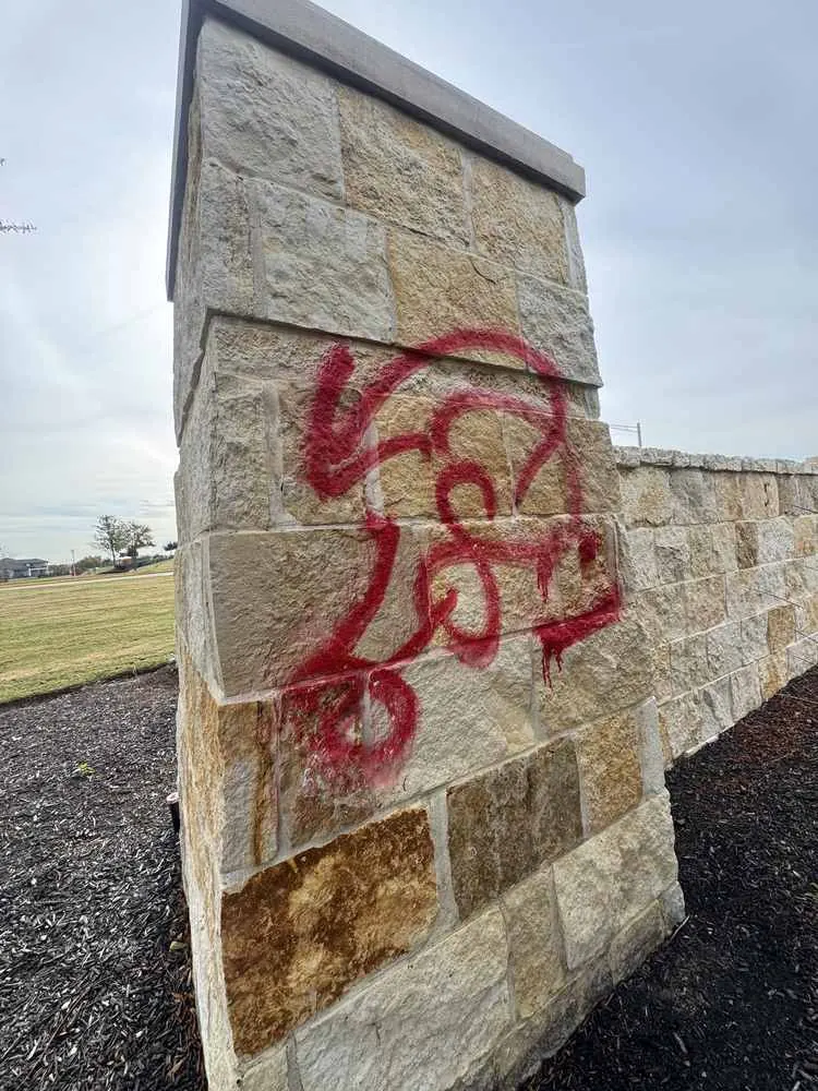 Stone column with graffiti before removal