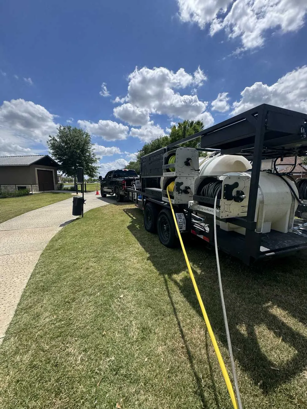 Mission Level Services pressure washing trailer rig at a Houston-area home